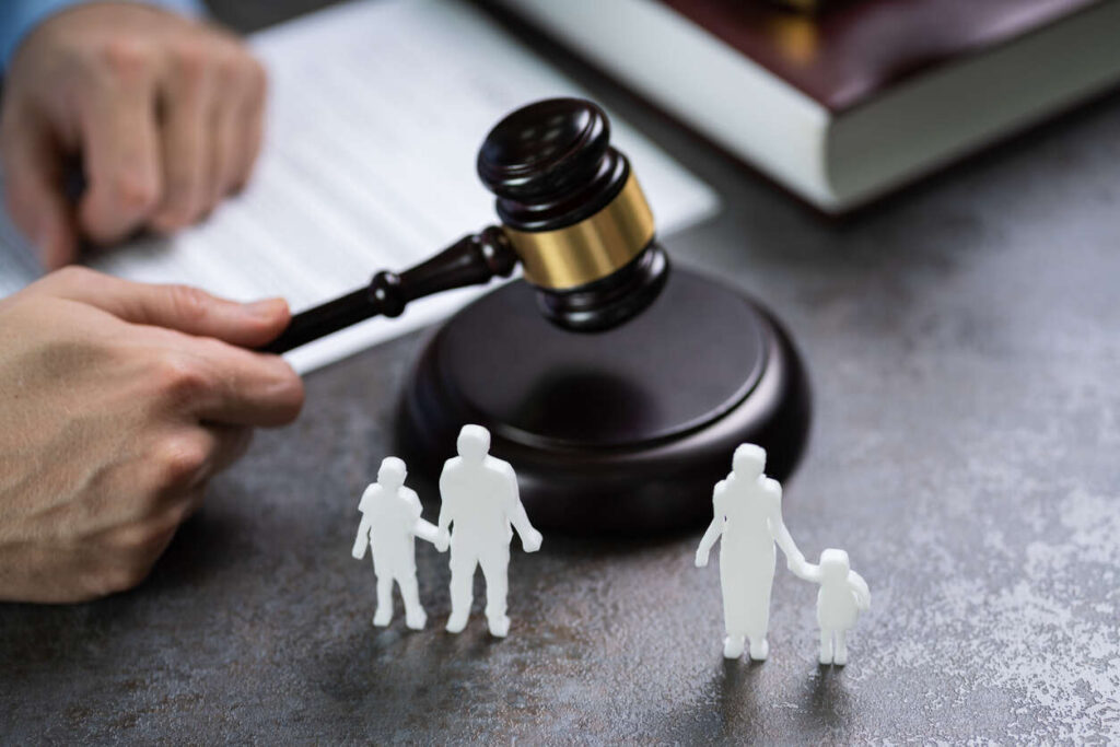 lawyer holding gavel on the table and father-child or mother-child statue 