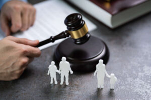 lawyer holding gavel on the table and father-child or mother-child statue