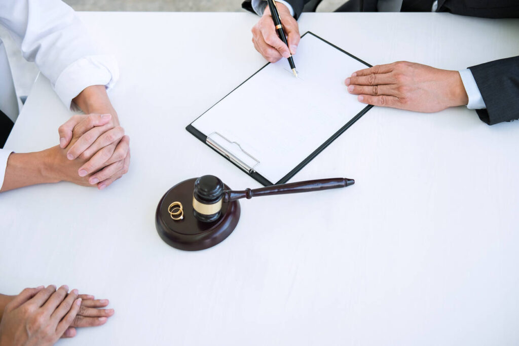 Agreement prepared by lawyer signing decree of divorce (dissolution or cancellation) of marriage. wife and hushband sitting next to lawyer