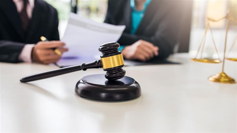lawyer gavel and two lawyers resolving 