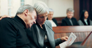 Grieving grandparents in a courtroom holding a photo, representing emotional family matters and grandparent visitation rights