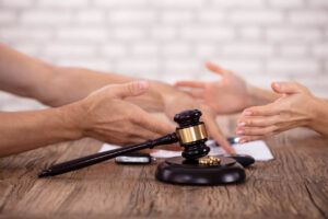 Judge’s gavel with wedding rings, passports, and legal documents symbolizing international relocation after divorce