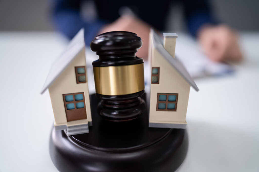 Legal separation concept with judge's gavel dividing model house, symbolizing property division and marital separation