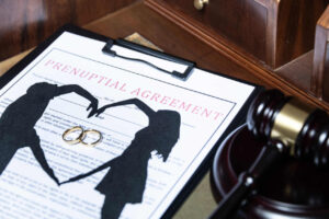 Prenuptial agreement form with wedding rings and judge’s gavel, symbolizing marital contracts and legal planning