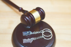 Judge’s gavel with split house keychains symbolizing property division in divorce proceedings