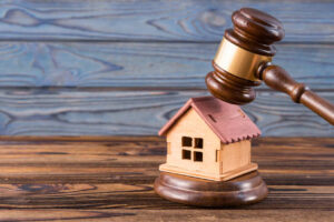 Gavel placed on a wooden house model, symbolizing property division in legal cases involving unmarried couples.