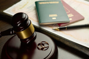 Judge’s gavel with wedding rings, passports, and legal documents symbolizing international relocation after divorce