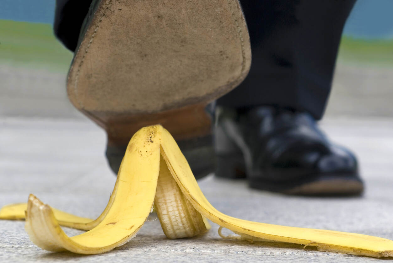 A person's shoe about to slip on a banana peel, symbolizing an injury caused by negligence.