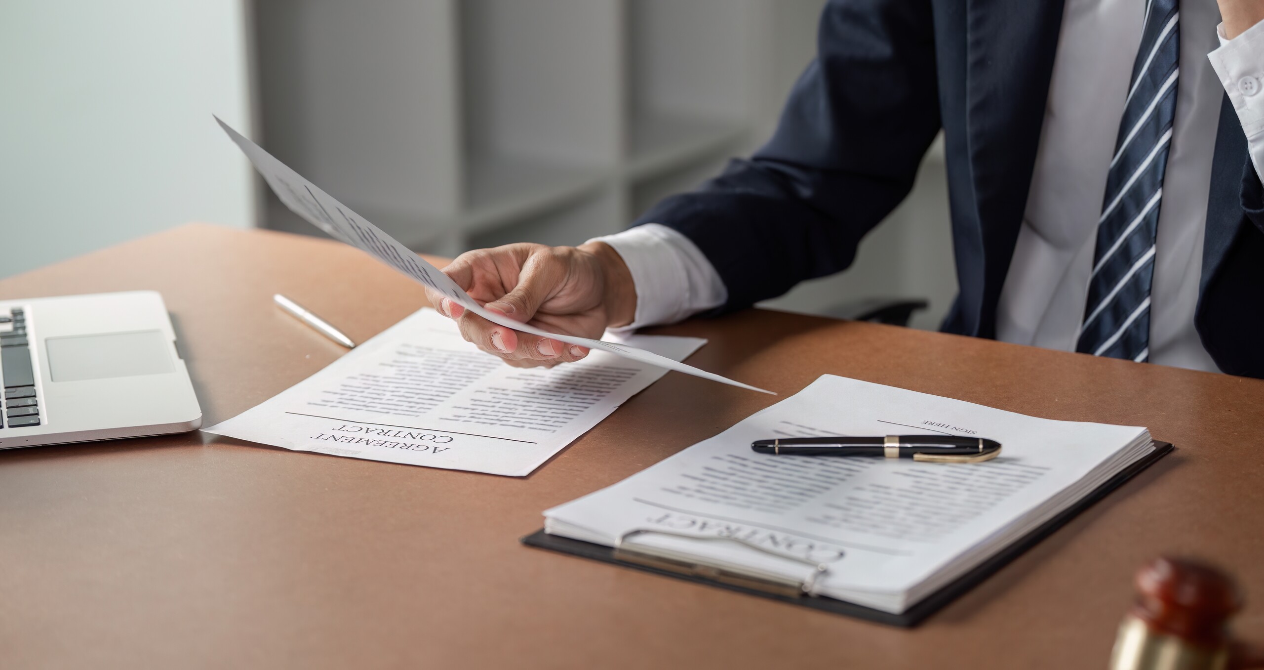 An attorney speaks with a client near a gavel and scales of justice during business litigation in Kansas City.