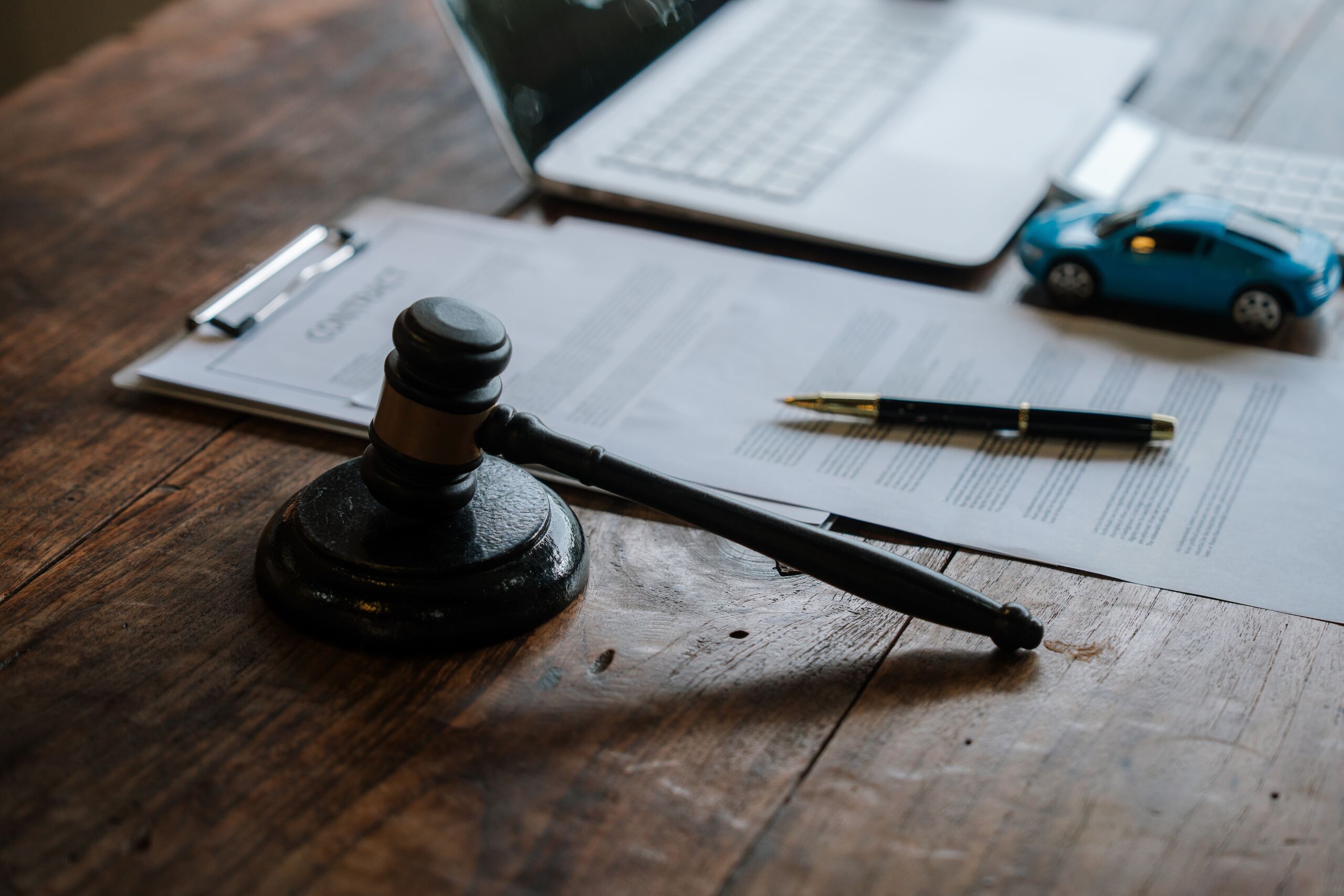A wooden legal gavel rests on business contract documents managed by Kansas City business litigation attorneys.