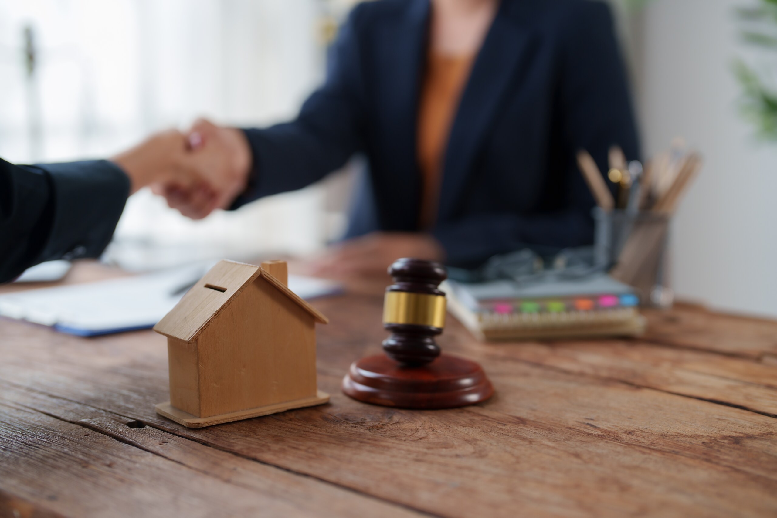 Attorney reviewing property documents next to a architectural house model for clients learning how to file a quiet title action in Missouri.